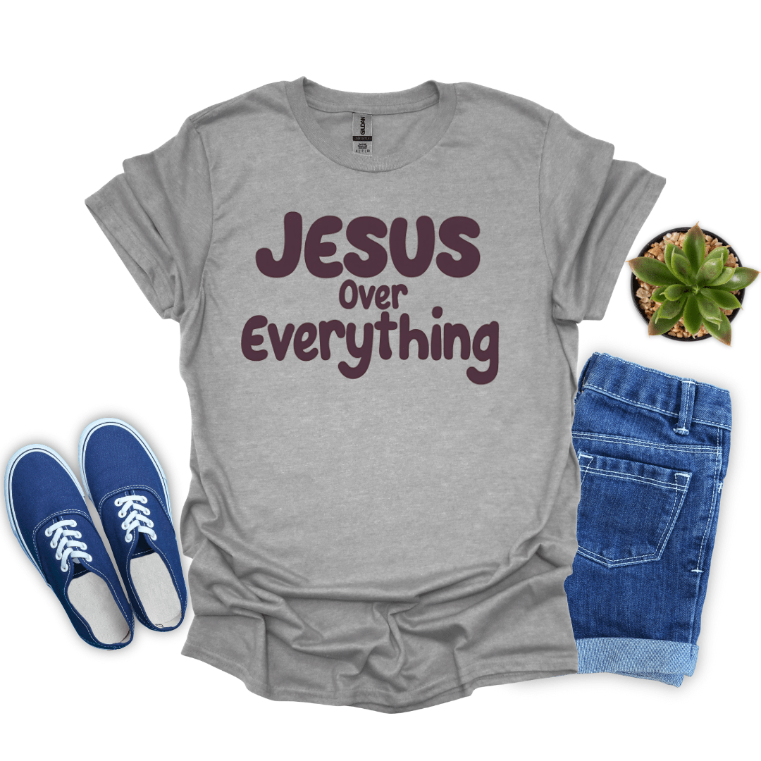 Sport Gray t-shirt with 'Jesus Over Everything' text, blue sneakers, and denim shorts on a white background.