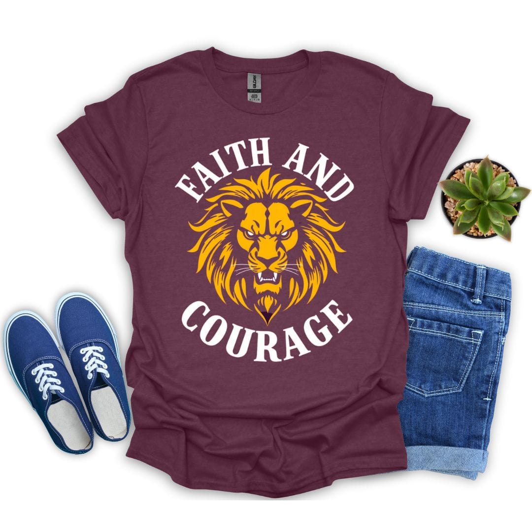 Heather maroon t-shirt with lion graphic and 'Faith and Courage' text, paired with blue sneakers and jeans on a white background.