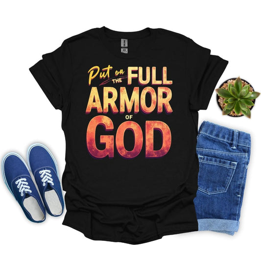 Black t-shirt with 'Put on the Full Armor of God' text, blue sneakers, jeans, and a plant on a white background