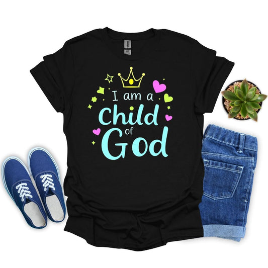 Black t-shirt with 'I am a Child of God' text, blue sneakers, jeans, and plant on a white background