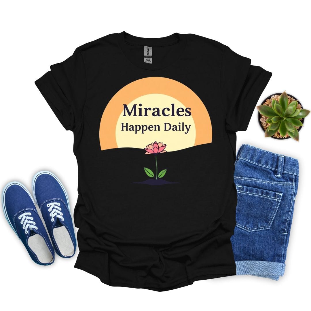 Black t-shirt with 'Miracles Happen Daily' design, blue sneakers, jeans, and a plant on a white background