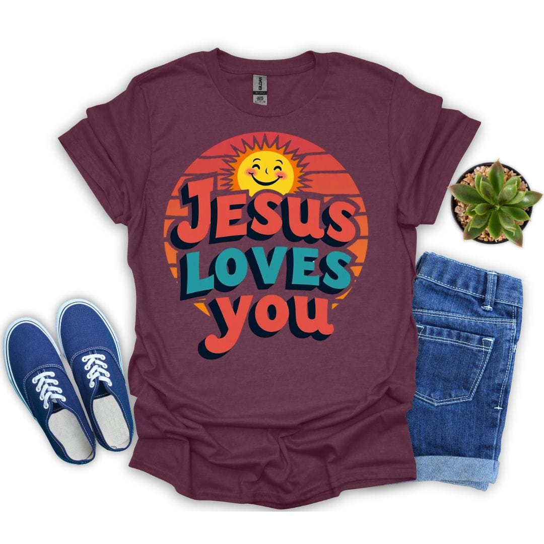 Heather maroon t-shirt with 'Jesus Loves You' graphic, blue sneakers, and jeans on a white background