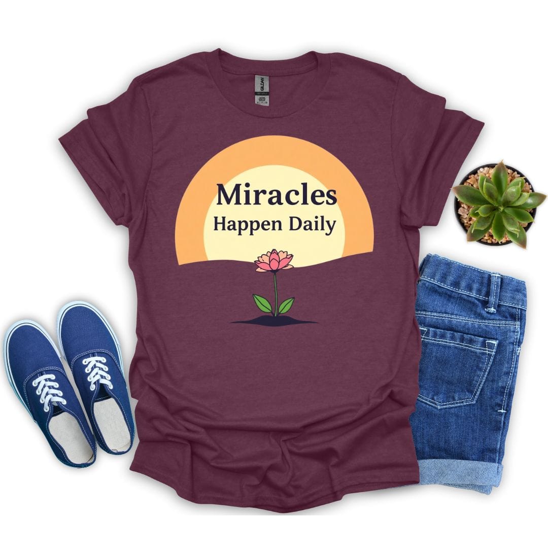 Heather maroon t-shirt with 'Miracles Happen Daily' graphic, blue sneakers, and jeans on a white background