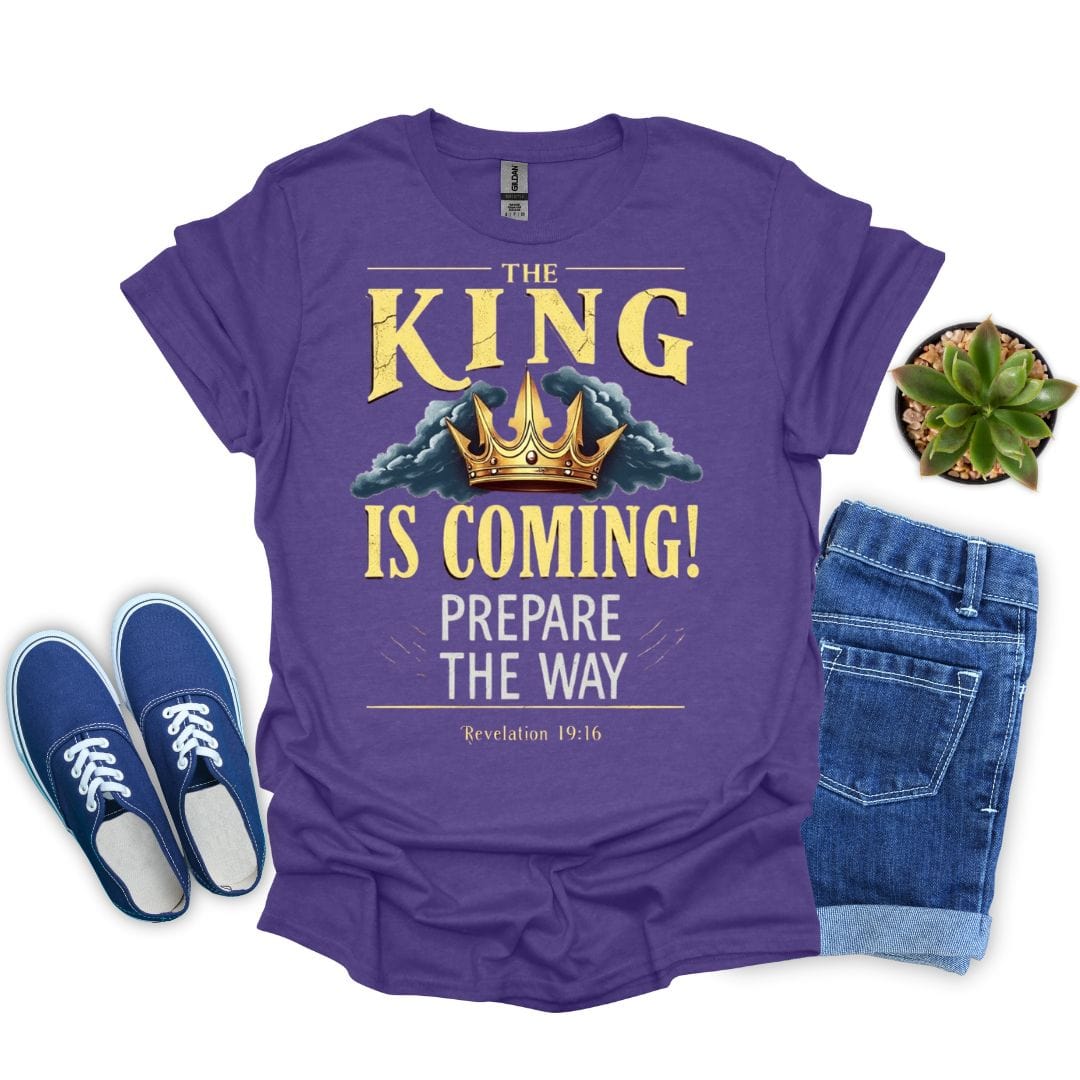 Heather purple t-shirt with 'The King is Coming!' text, blue sneakers, and jeans on a white background
