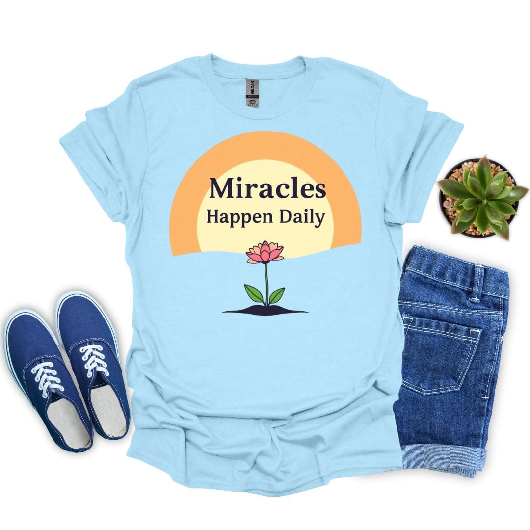 Light blue t-shirt with 'Miracles Happen Daily' design, paired with blue sneakers and jeans on a white background.