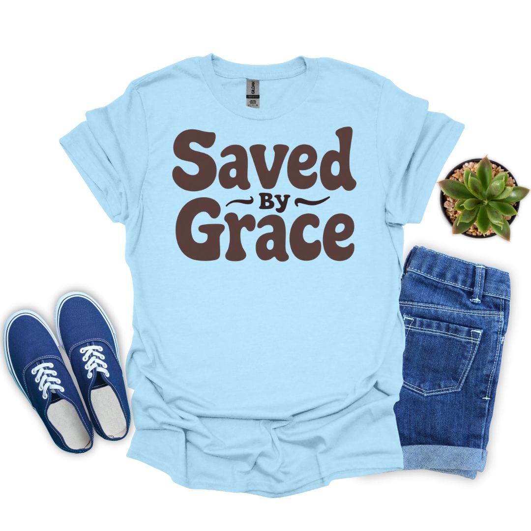 Light blue t-shirt with 'Saved by Grace' text, paired with blue sneakers and jeans on a white background.