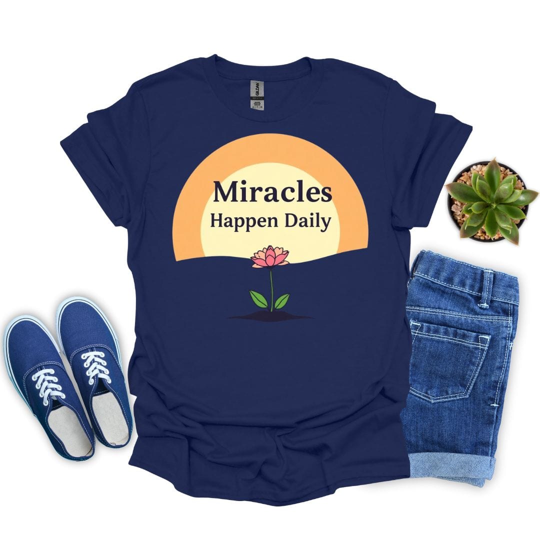 Navy blue t-shirt with 'Miracles Happen Daily' design, paired with blue sneakers and jeans on a white background.