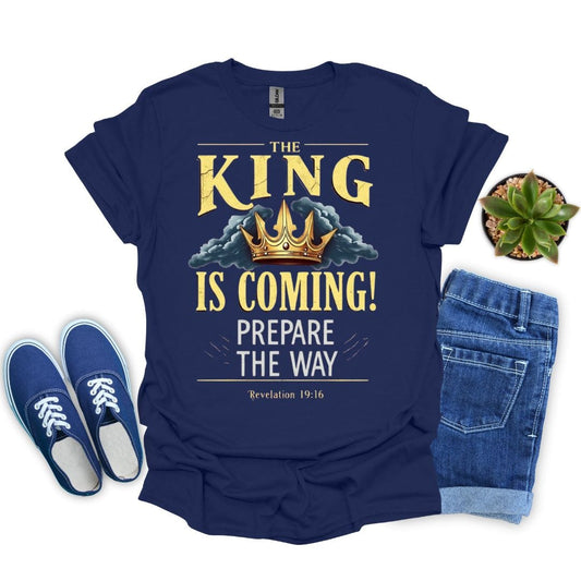 Navy blue t-shirt with 'The King is Coming!' text and shoes, jeans, and plant on a white background