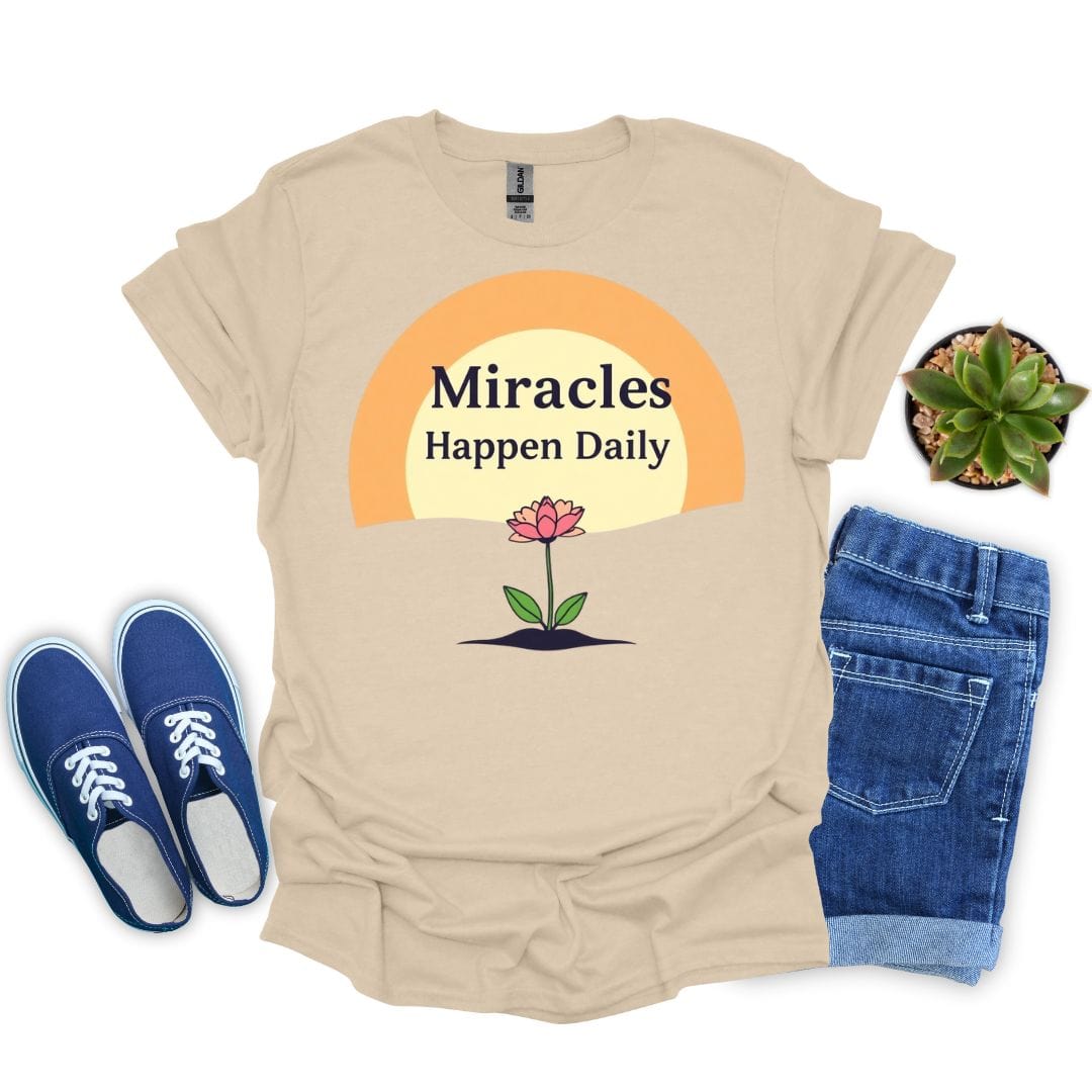 Sand t-shirt with 'Miracles Happen Daily' graphic, blue sneakers, and jeans on a white background